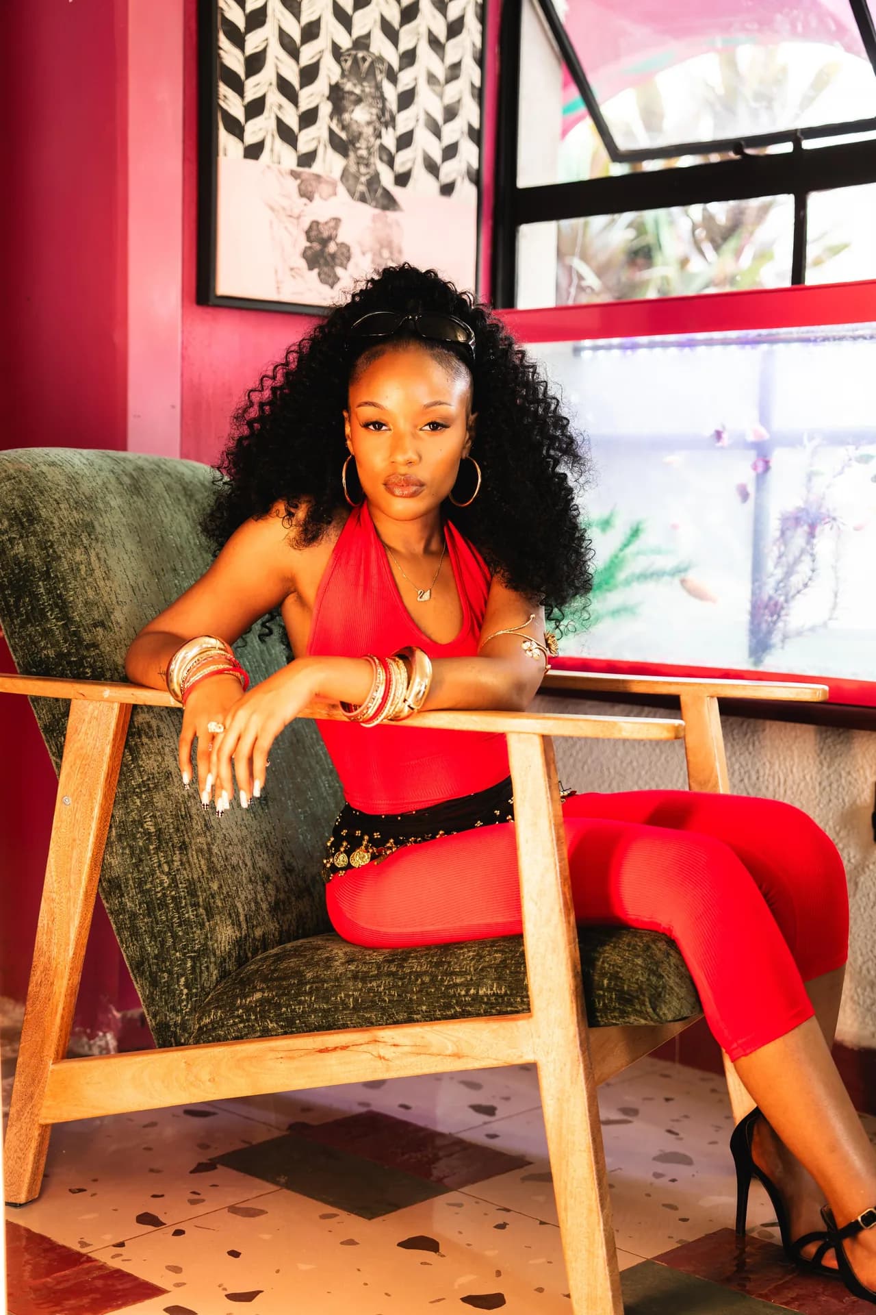 Tipilda seated on a terrace in a red outfit